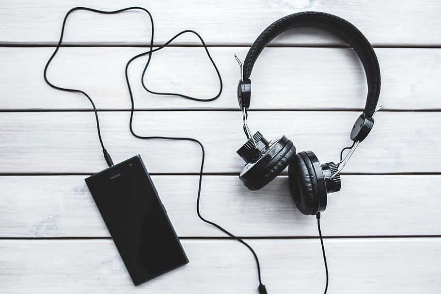 Black smartphone and headphones with various items, books, mobile phone, HD wallpaper